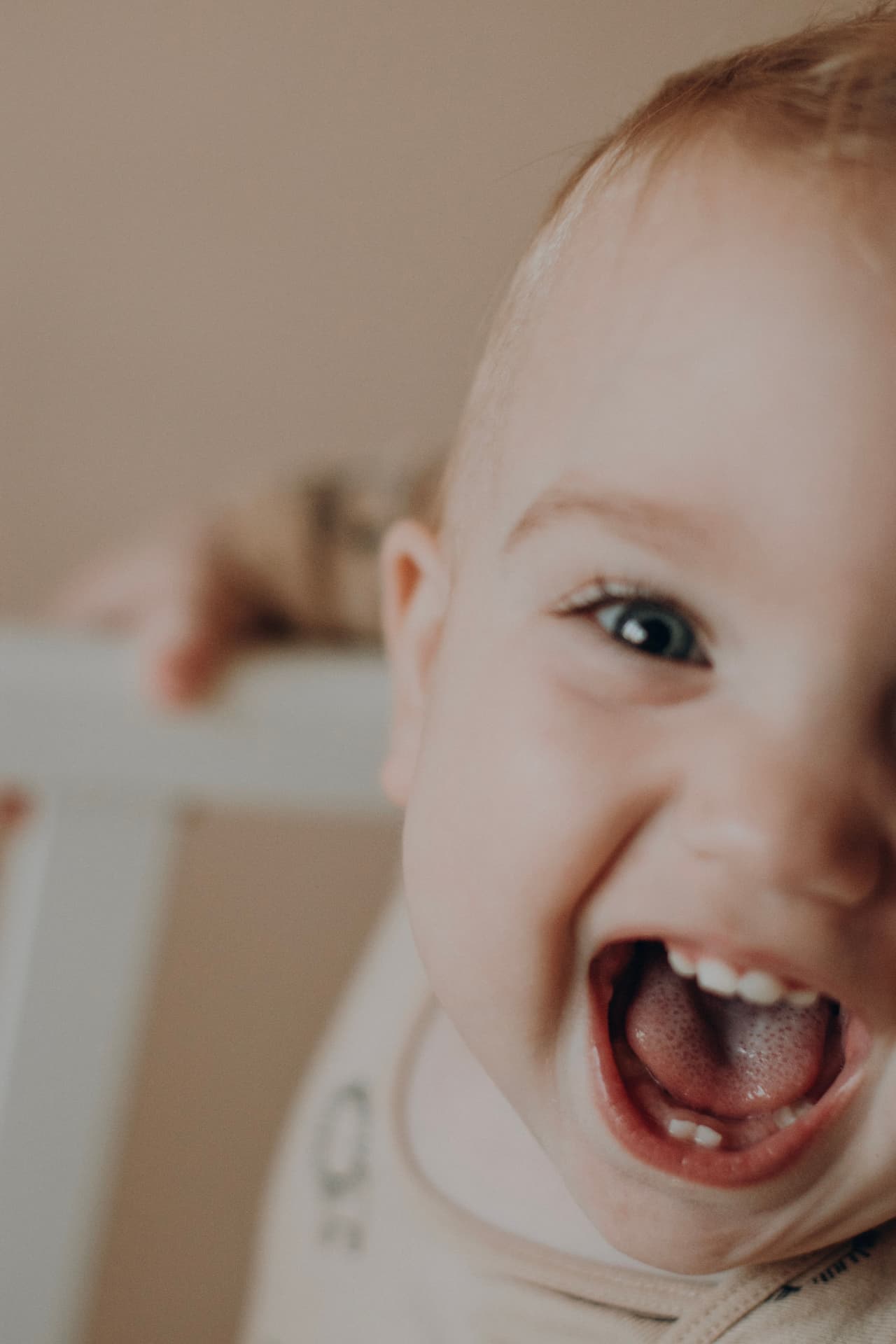 A laughing baby showing their first teeth