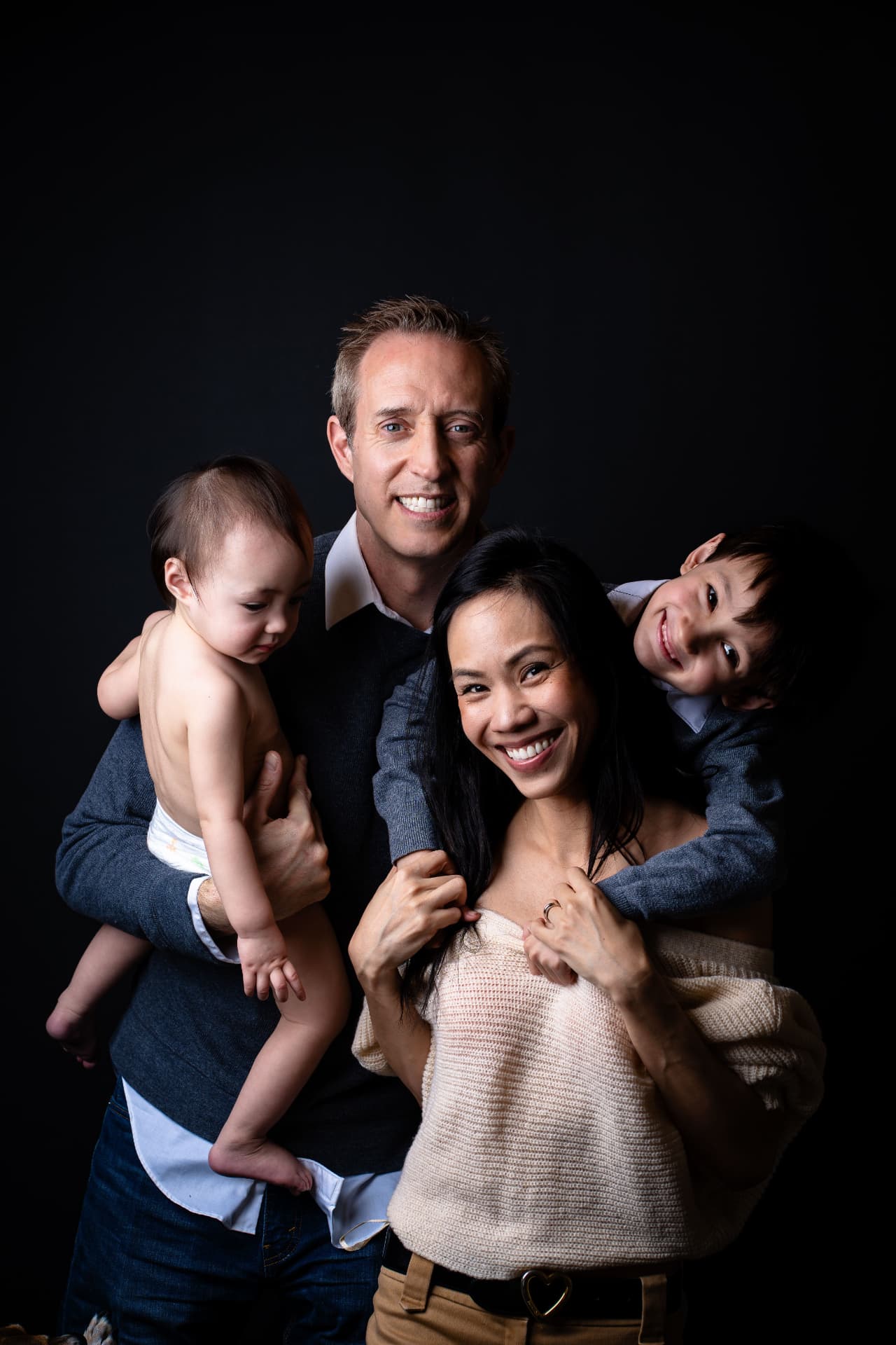 A family with young children smiling together
