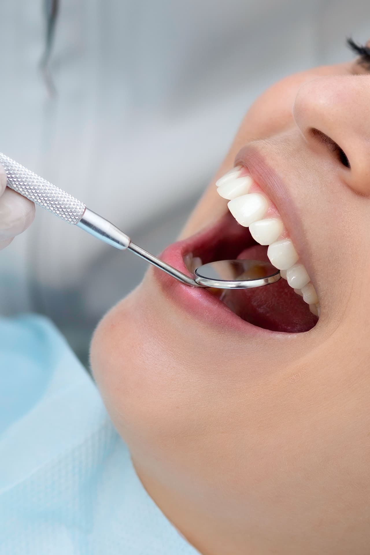 A dentist examining a patient's teeth with a mouth mirror